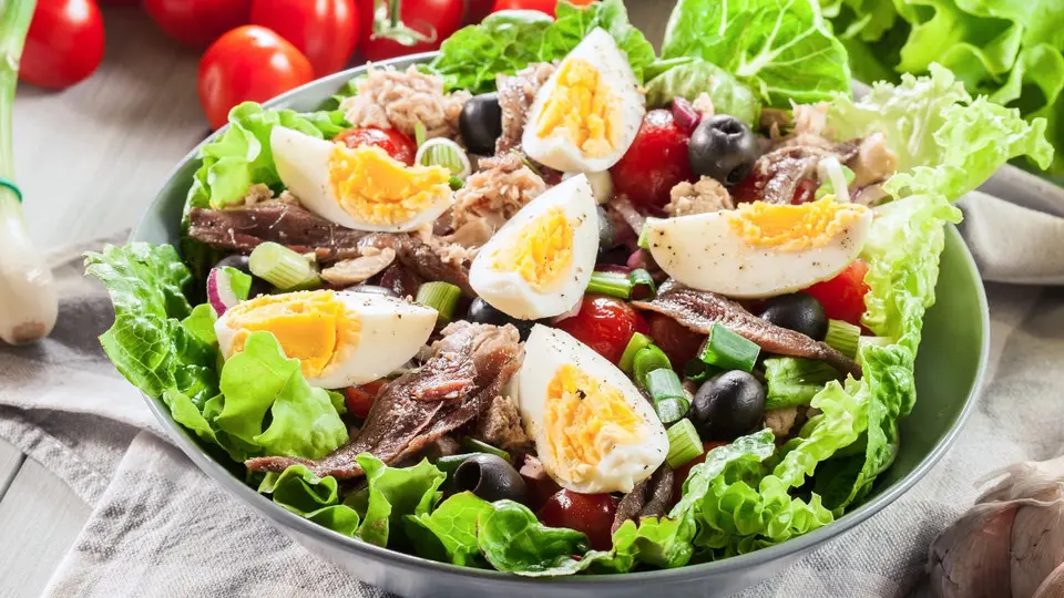 French Salade Niçoise on a plate with tuna, eggs, beans, and olives